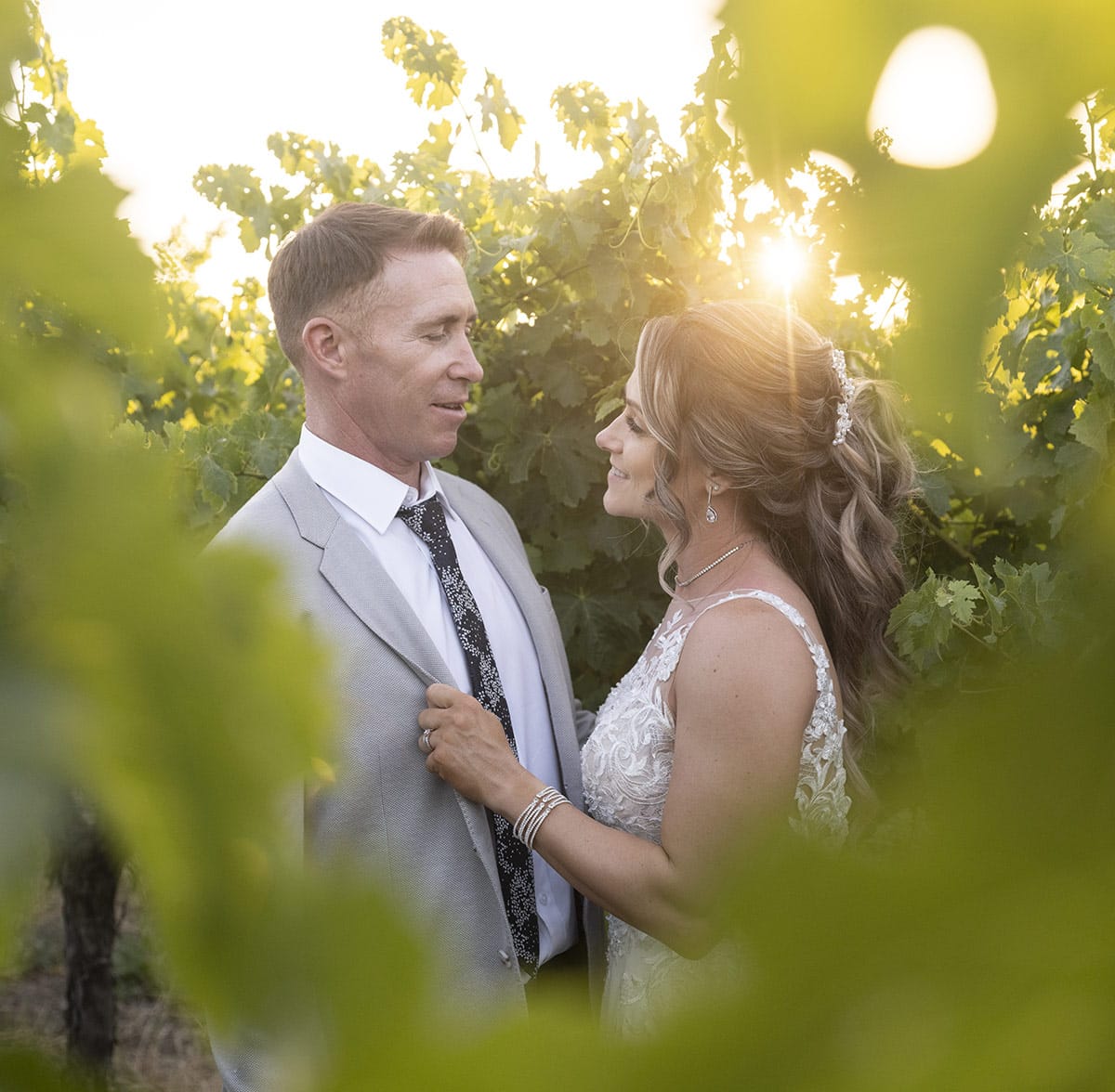sun shining through vines on bride and groom Sun shining through vines on bride and groom